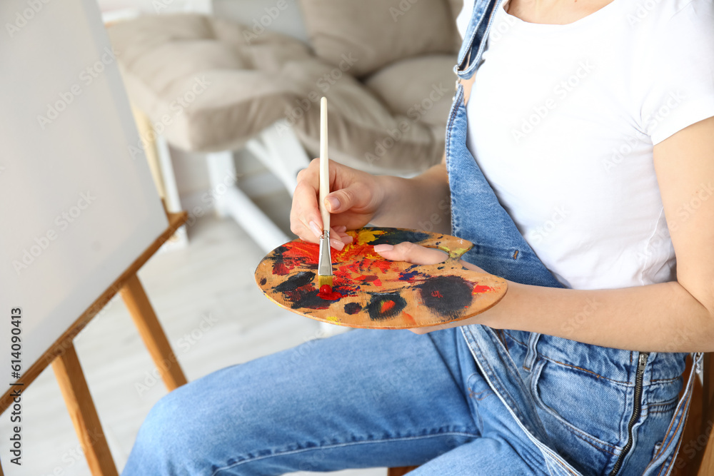 Female artist painting picture in  workshop