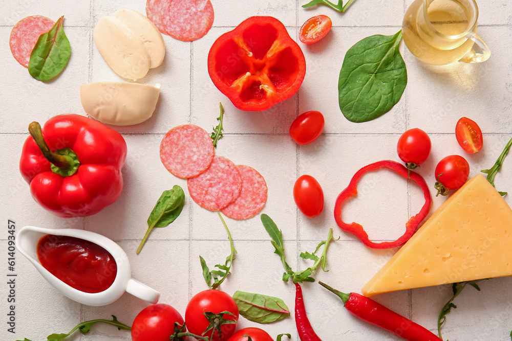 Different ingredients for preparing pizza on white tile background