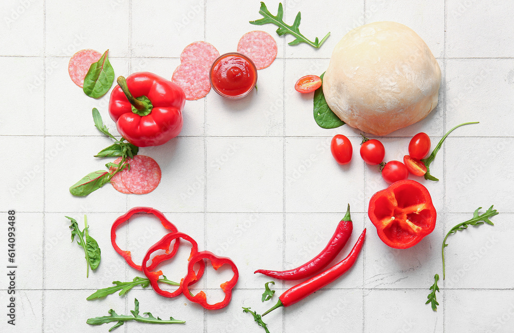 Frame made of ingredients for preparing pizza on white tile background