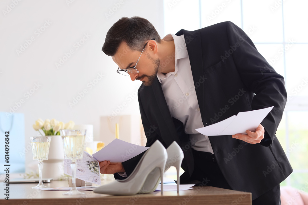 Male wedding planner working with pictures in office