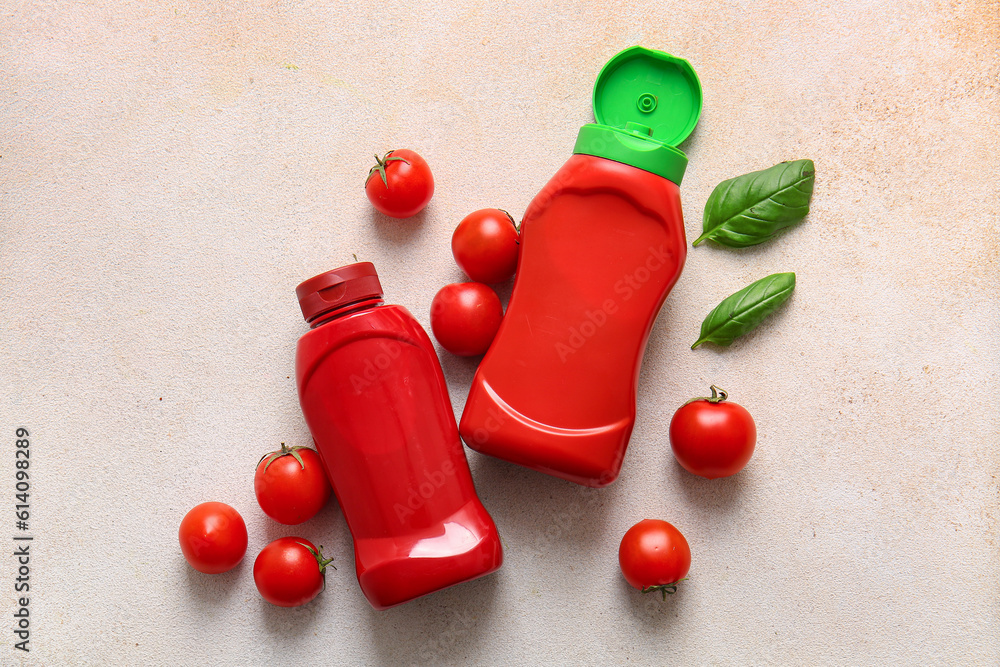 Bottles of ketchup and tomatoes on white background