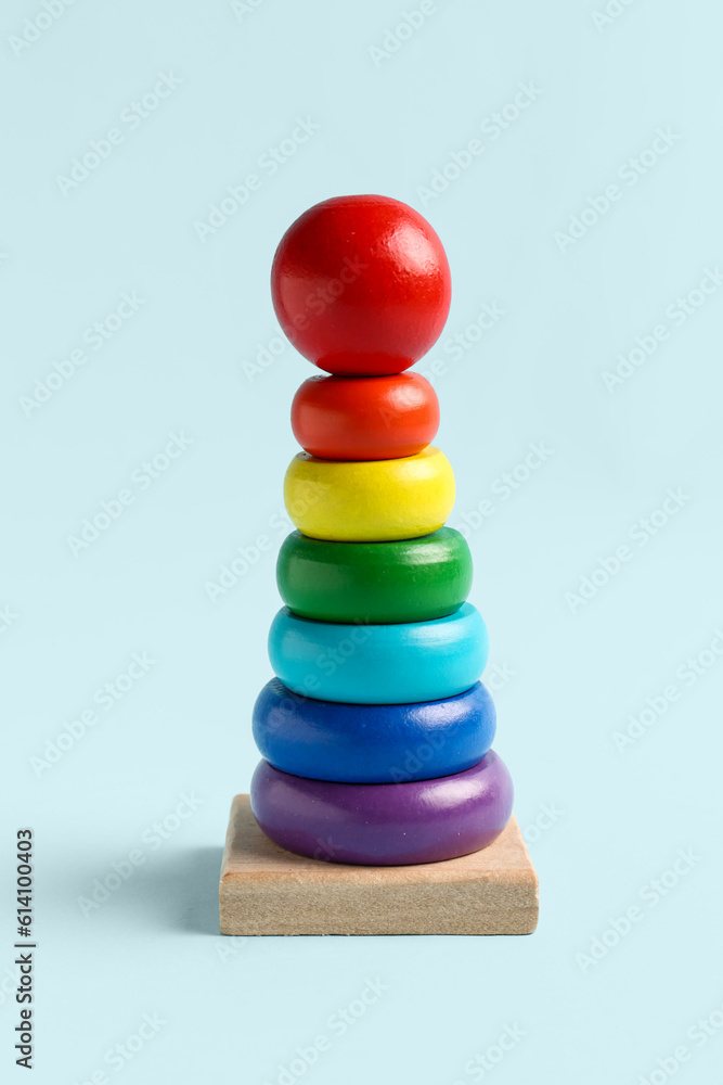 Wooden colorful toy pyramid on blue background. Childrens Day celebration