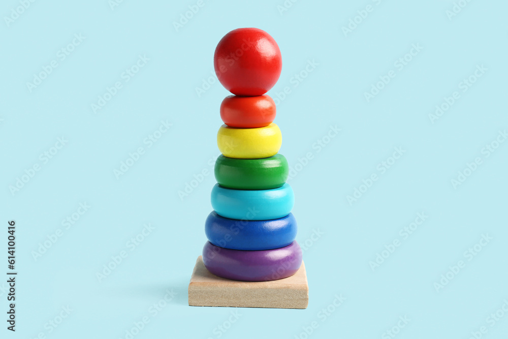 Wooden colorful toy pyramid on blue background. Childrens Day celebration