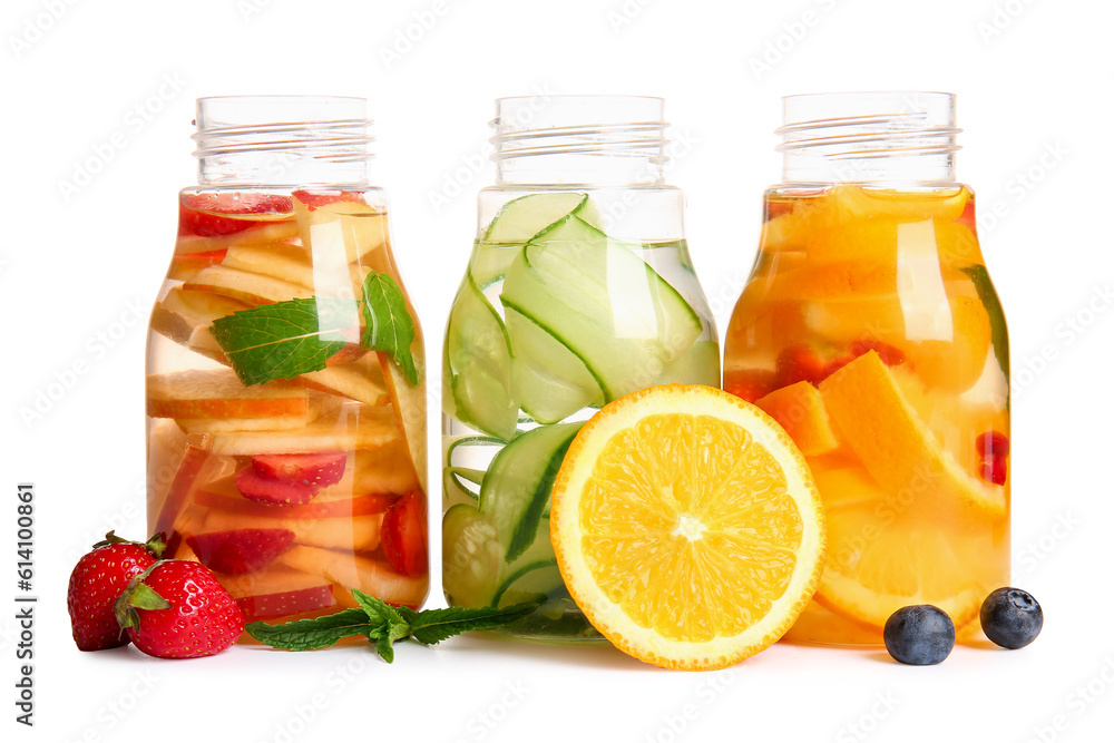 Bottles of infused water with different sliced fruits on white background