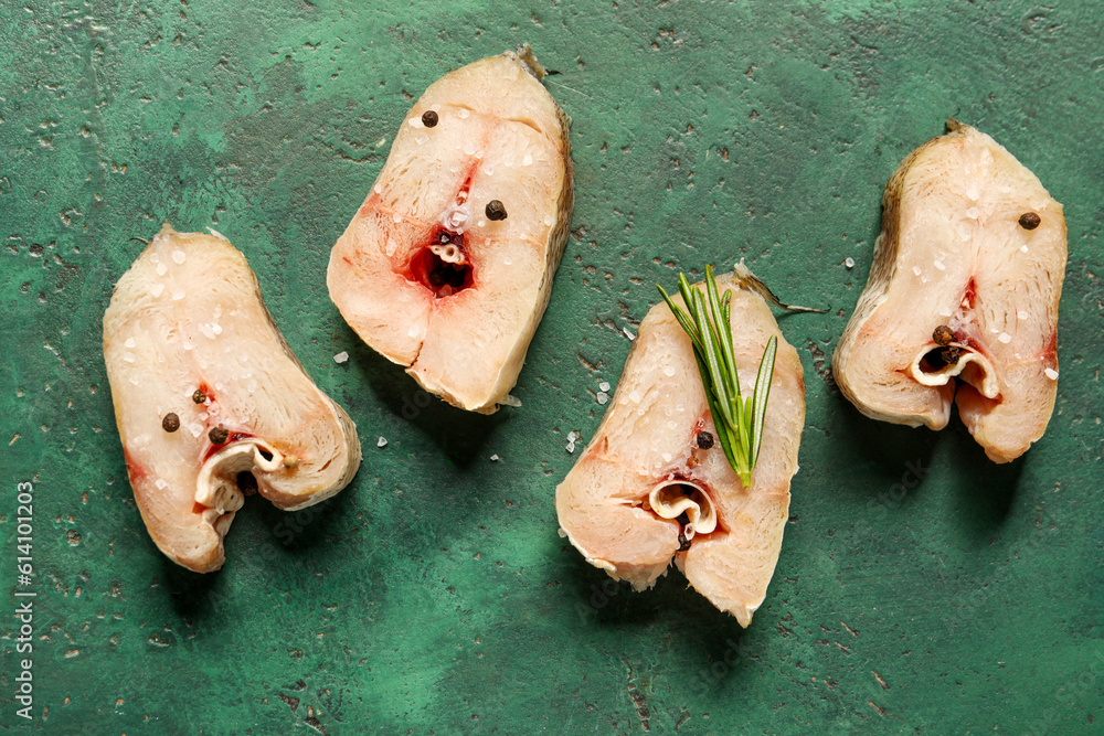 Pieces of raw codfish on green background