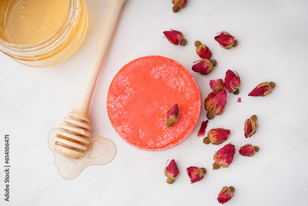 Handmade solid shampoo with honey and dry flowers on light background