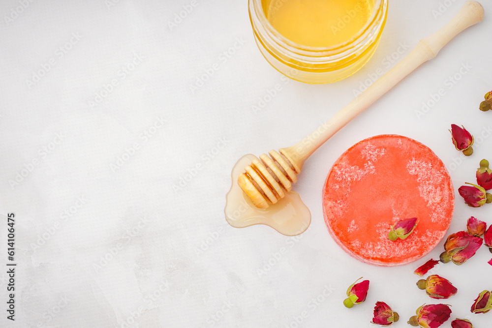 Handmade solid shampoo with honey and dry flowers on light background