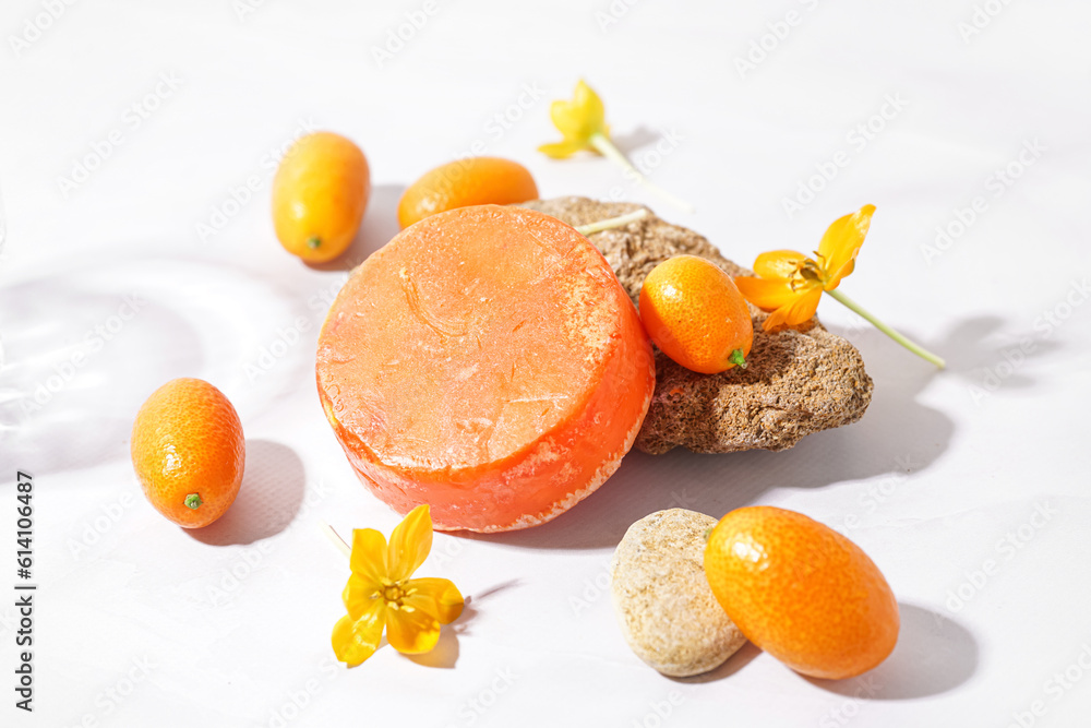 Handmade solid shampoo, flowers and kumquats on light background, closeup