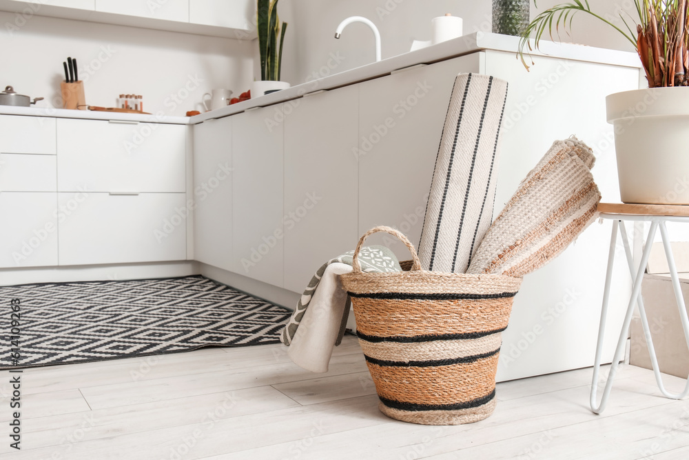 Basket with different rugs in interior of modern kitchen