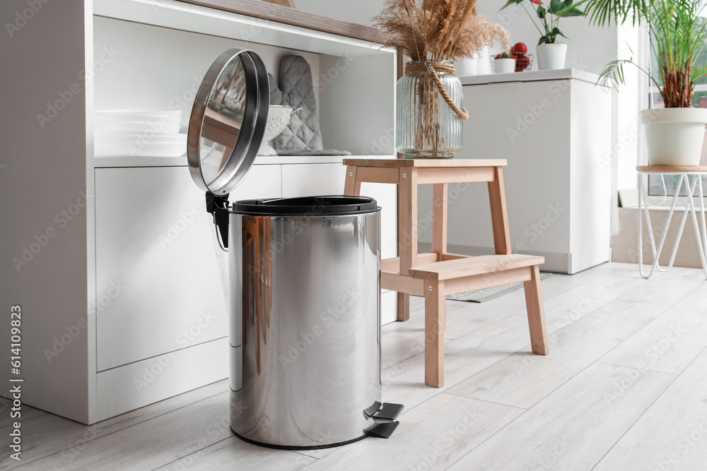 Opened metallic trash bin in interior of modern kitchen