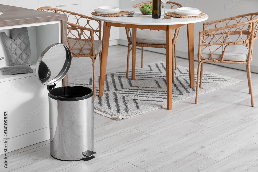 Opened metallic trash bin in interior of modern kitchen