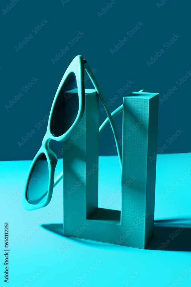 Podium with stylish sunglasses on blue background