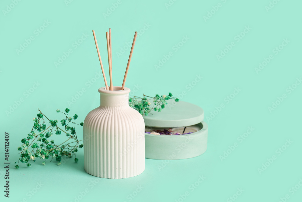 Floral reed diffuser and gypsophila flowers on turquoise background