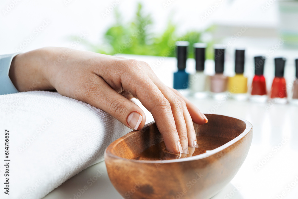 Closeup female hands in wooden bowl with water