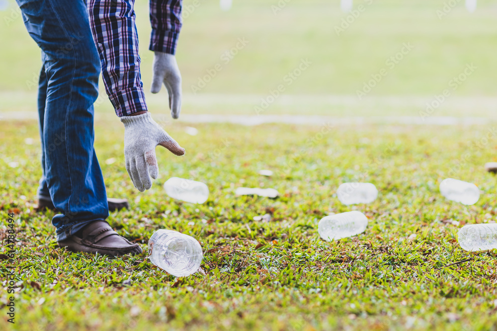 Volunteers picking up plastic bottles on the parks lawn.