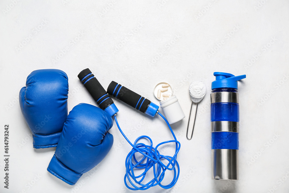 Sports equipment, bottle of water, amino acid pills and powder on light background