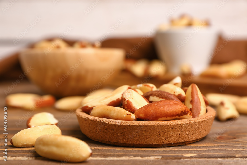 Plate of Brazil nuts on wooden table, closeup