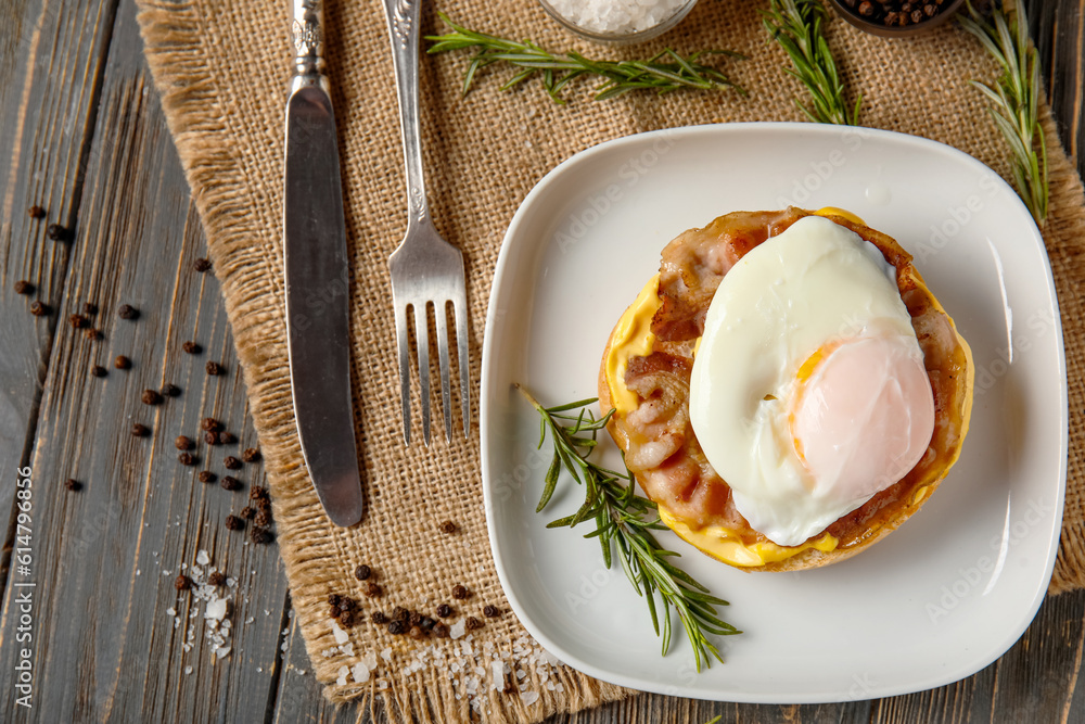 Plate with tasty egg Benedict on dark wooden background