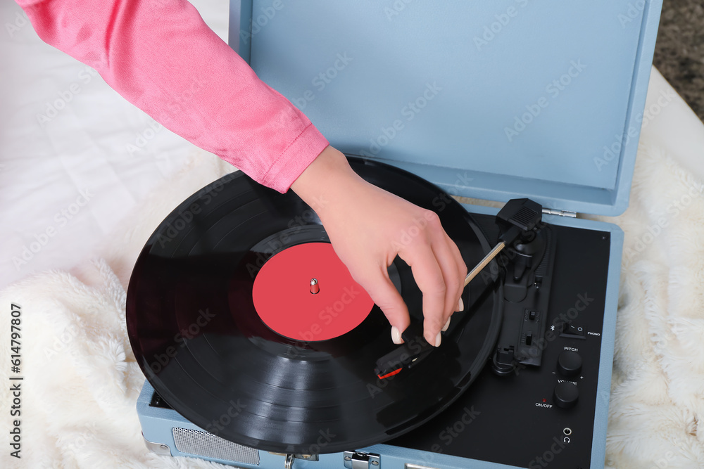 Young woman with record player in bedroom, closeup