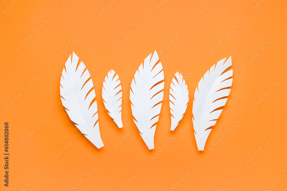 White paper tropical leaves on orange background