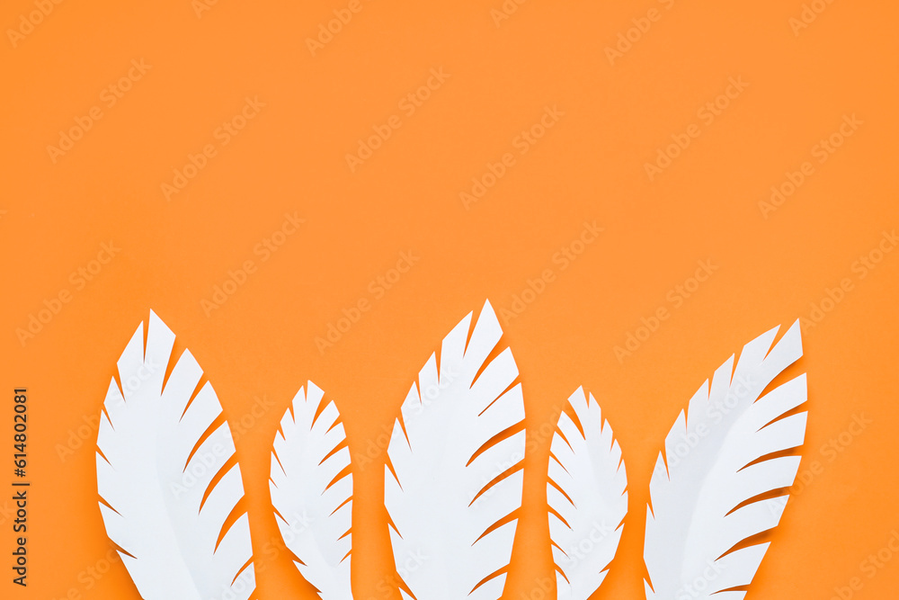 White paper tropical leaves on orange background