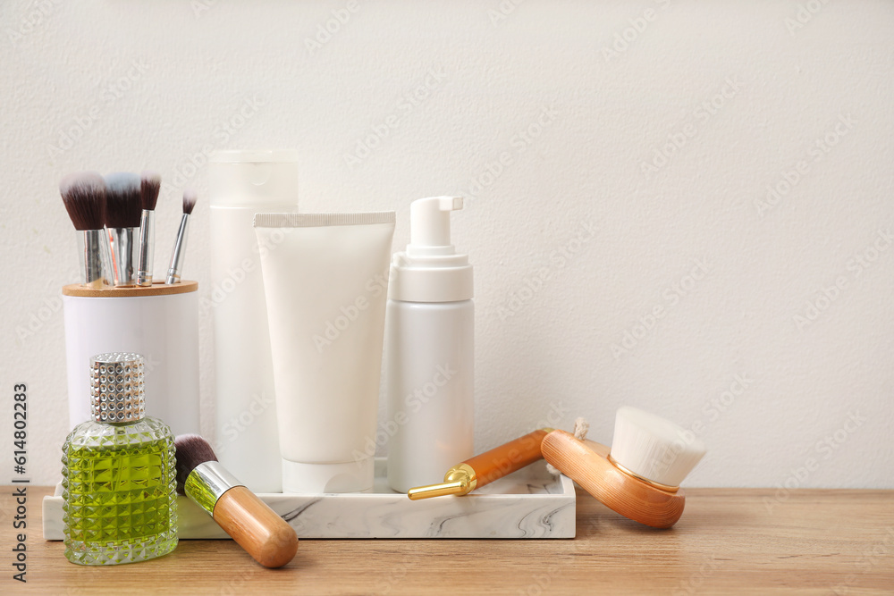 Bath accessories with brushes on table near light wall