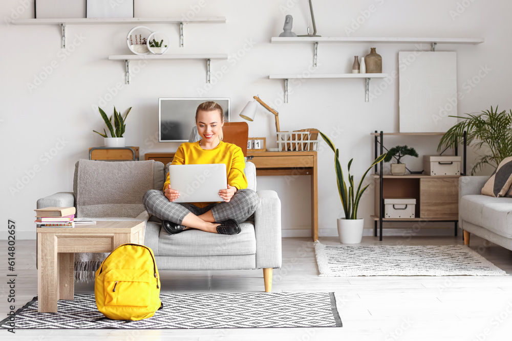 Female student studying online with laptop at home