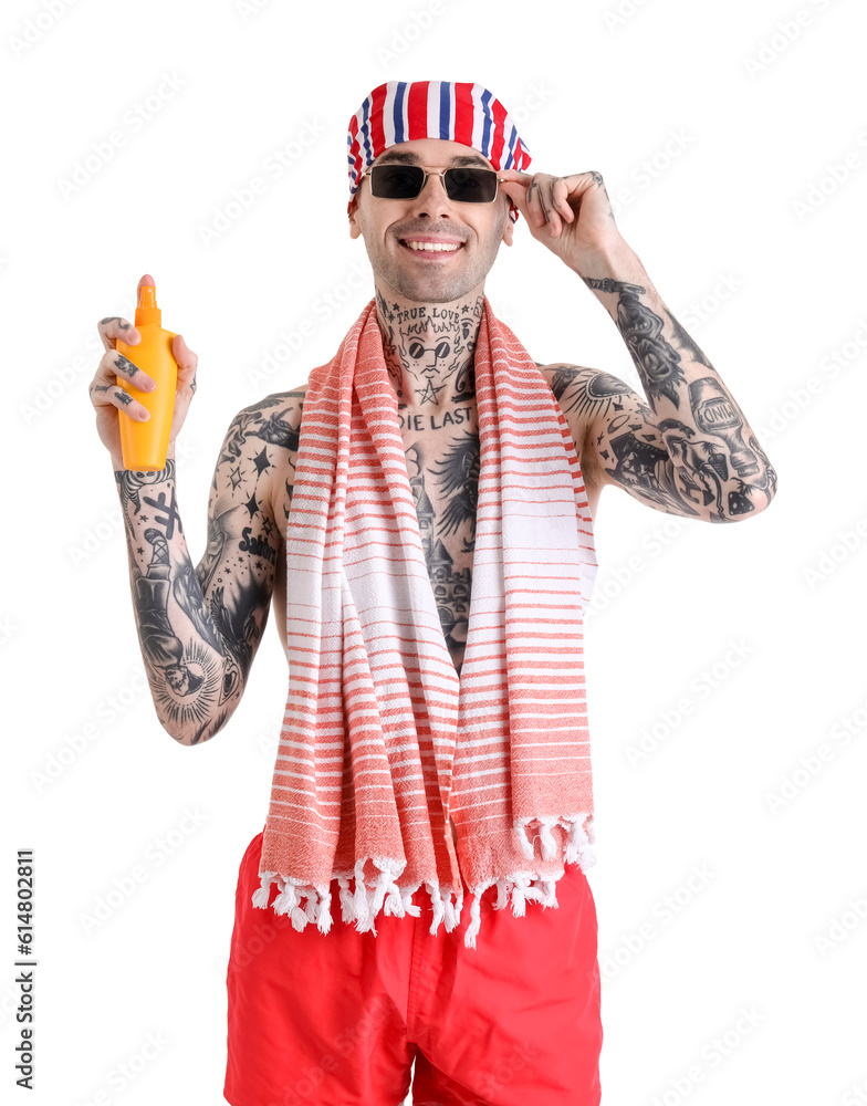 Tattooed man with sunscreen cream on white background