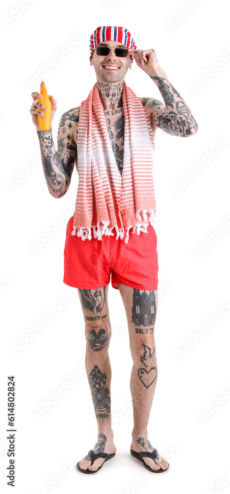 Tattooed man with sunscreen cream on white background