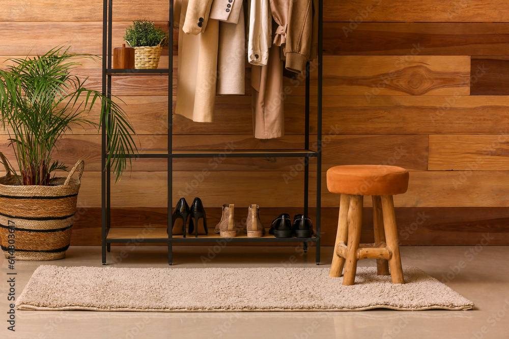 Rack with outwear and shoes in interior of hall