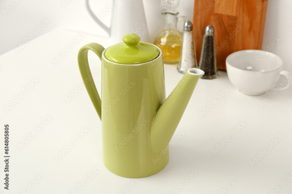 Composition with teapot, cup and different items on white table