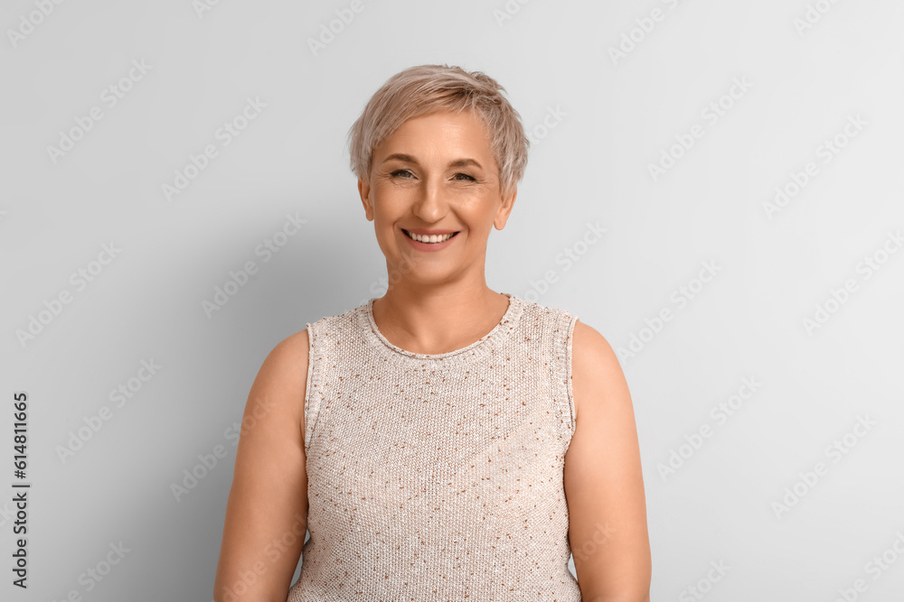 Mature blonde woman on light background