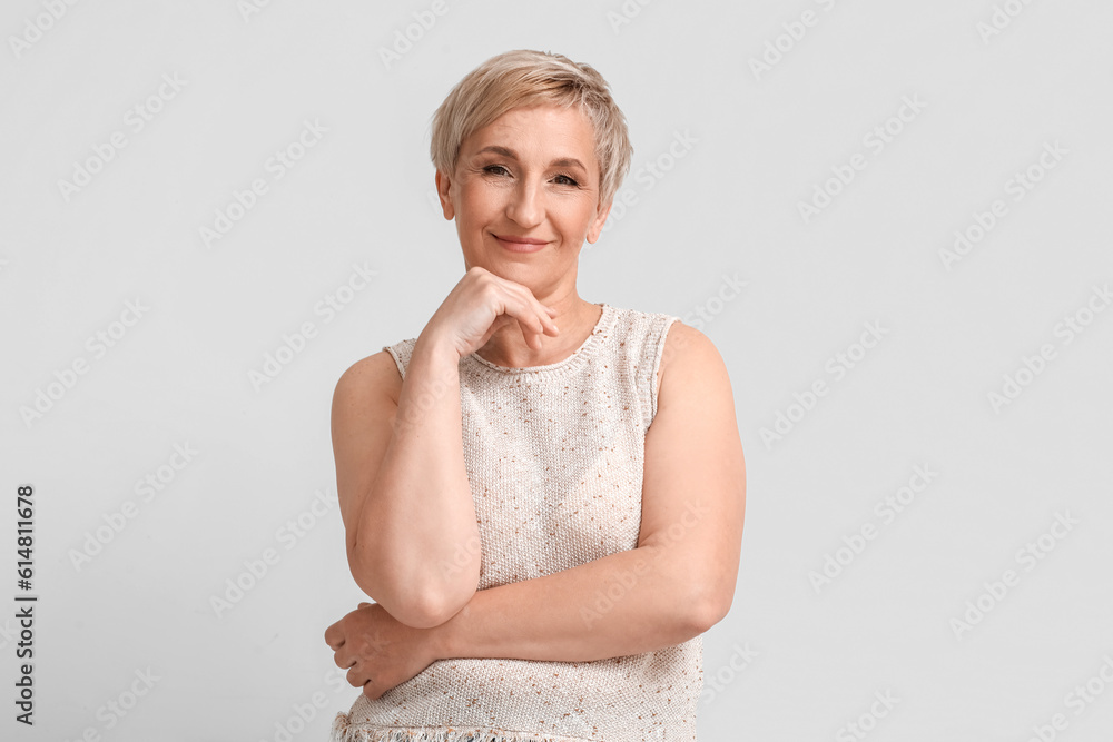 Mature blonde woman on light background