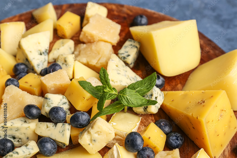 Plate with pieces of tasty cheese on table, closeup