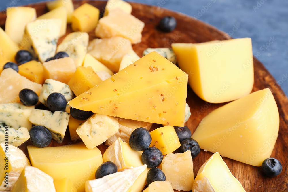 Plate with pieces of tasty cheese on table, closeup