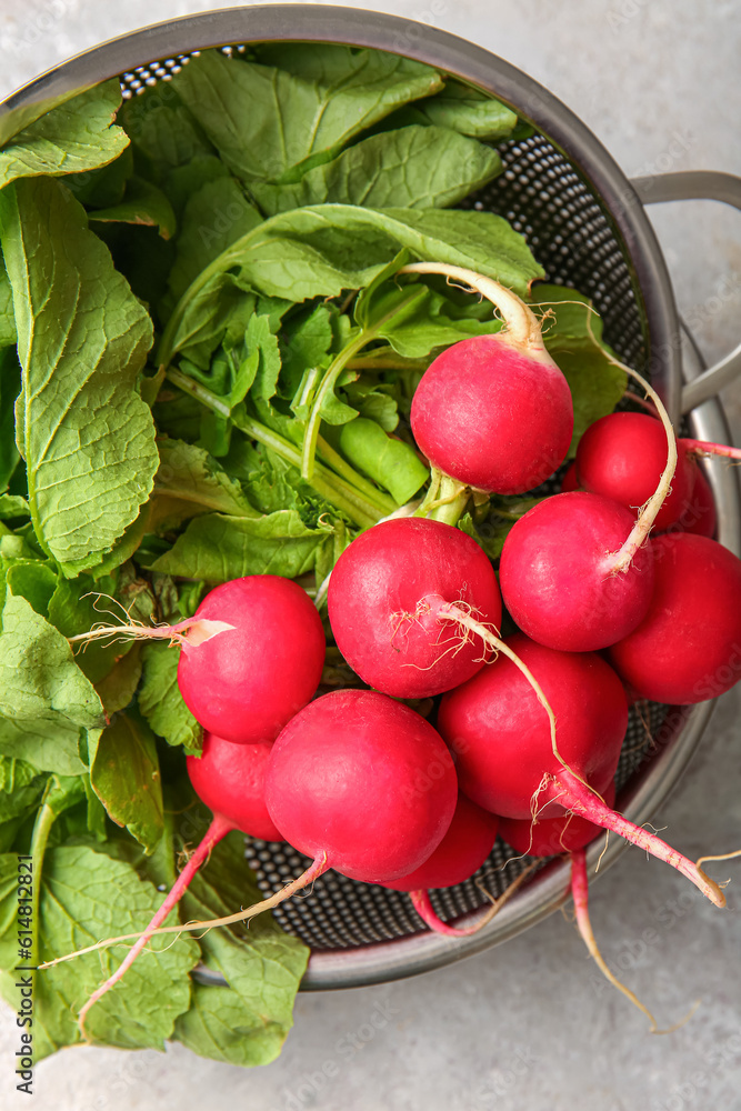 Colanders with fresh radish on light background