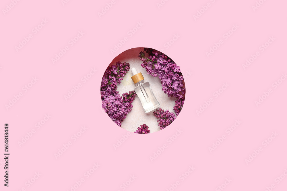 Composition with bottle of lilac essential oil and flowers on pink background