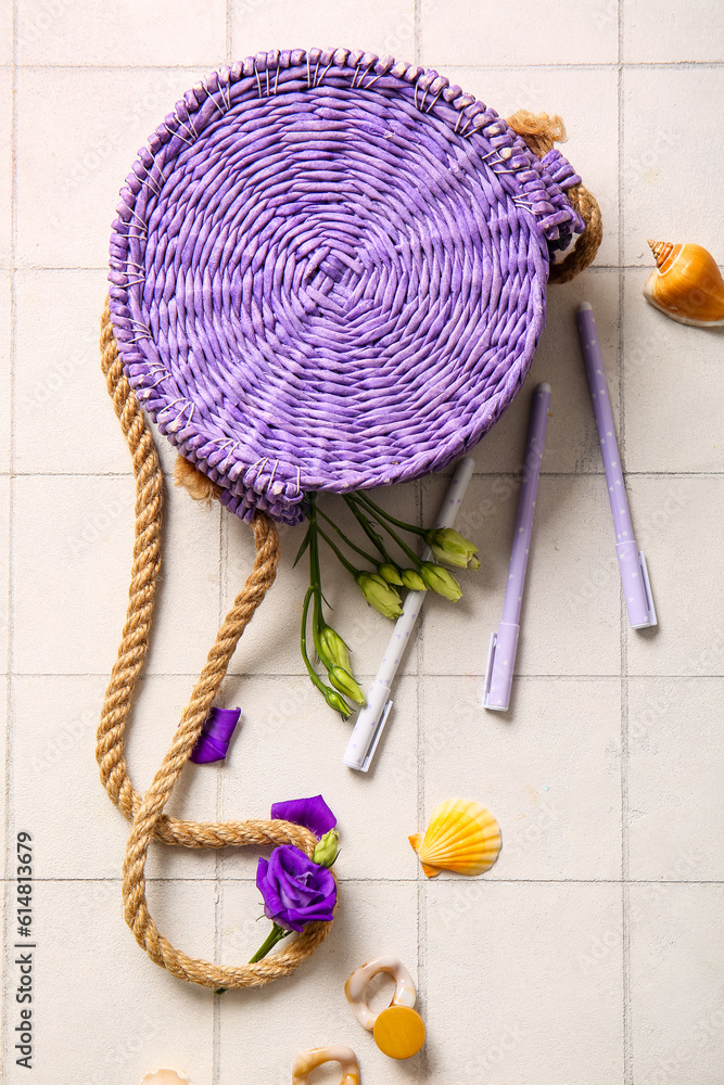 Stylish bag with pens and earrings white tile background