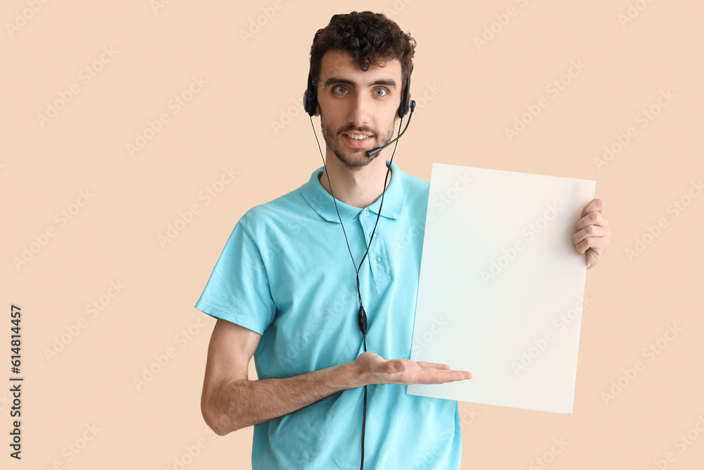 Male technical support agent with blank poster on beige background