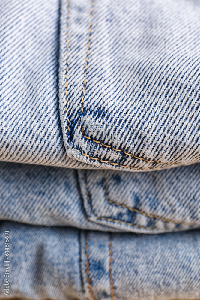 Stack of different stylish jeans as background, closeup