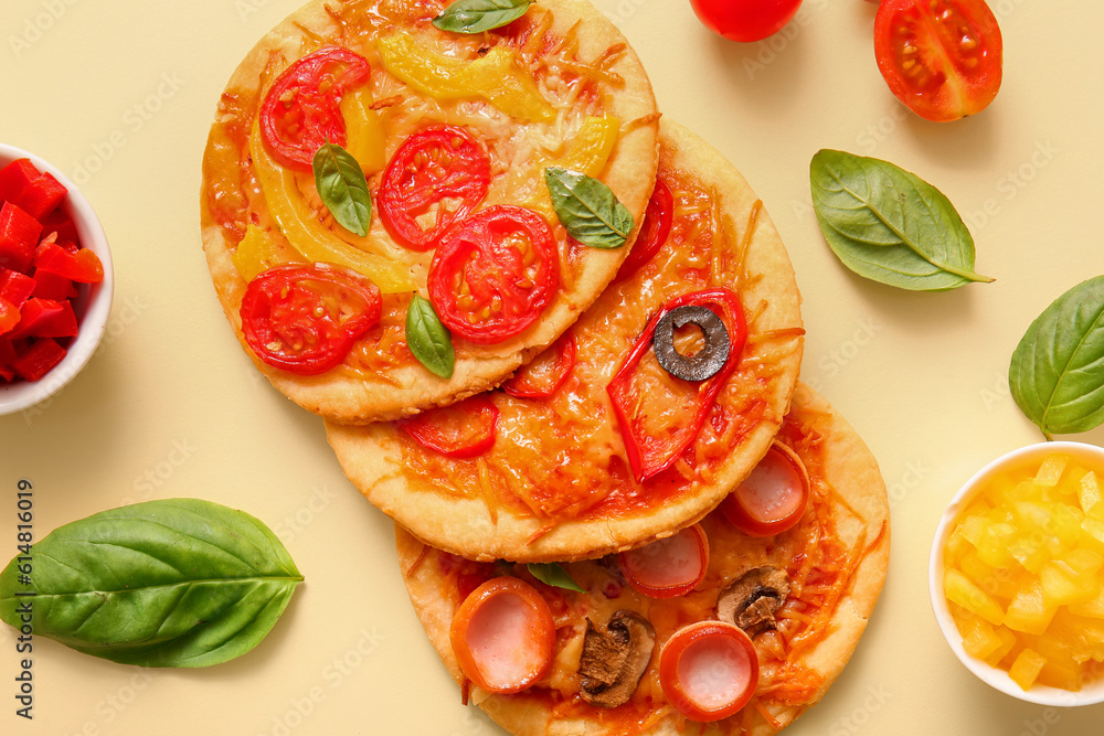 Different tasty mini pizzas on yellow background