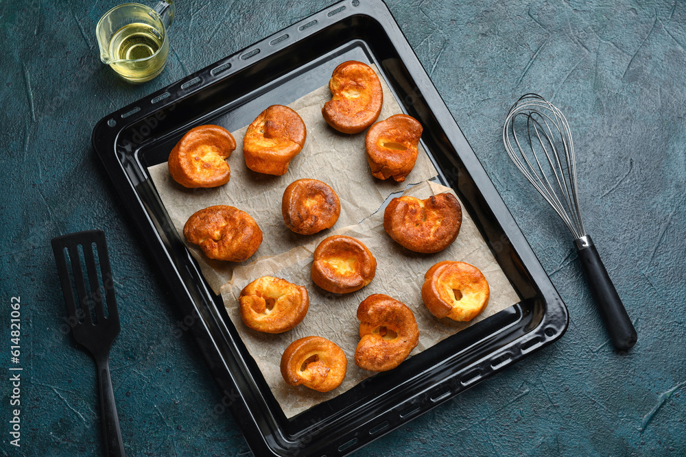 Baking tray with tasty Yorkshire pudding on blue background