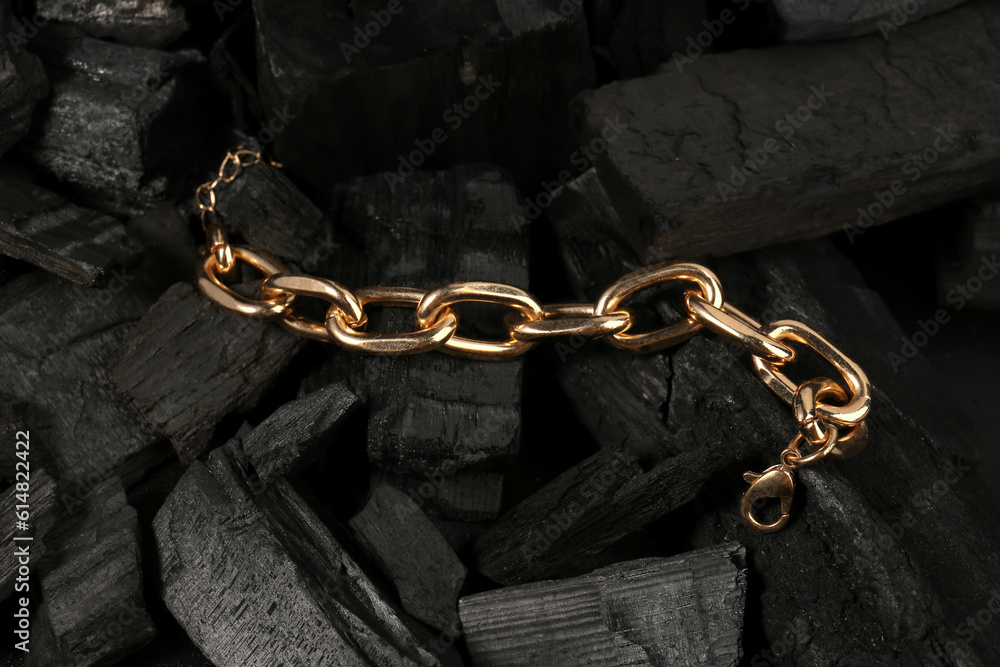 Beautiful chain bracelet on black charcoal, closeup