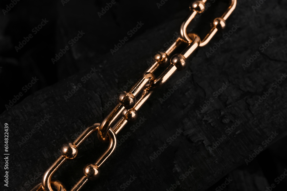 Beautiful chain bracelet on black charcoal, closeup