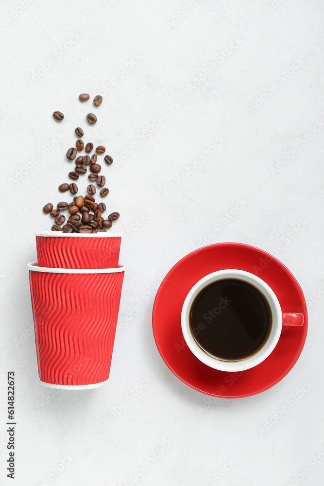 Cups with beans and hot espresso on light background