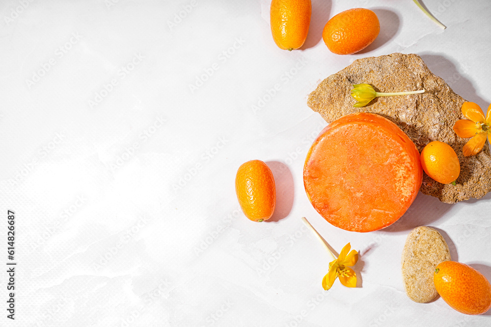 Handmade solid shampoo, flowers and kumquats on light background