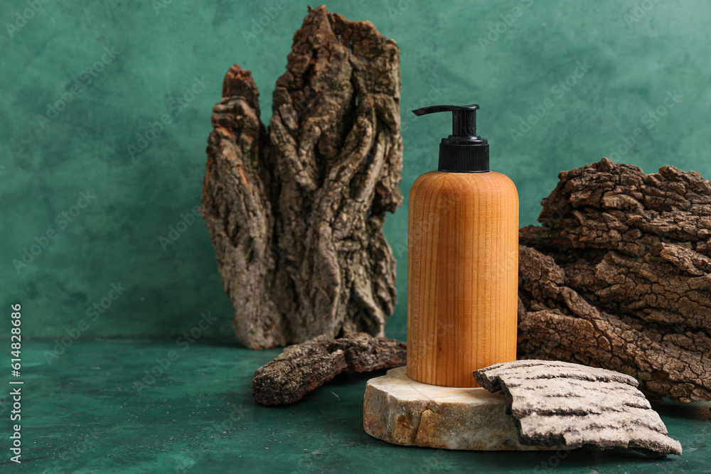 Composition with bottle of cosmetic product and tree bark on color background