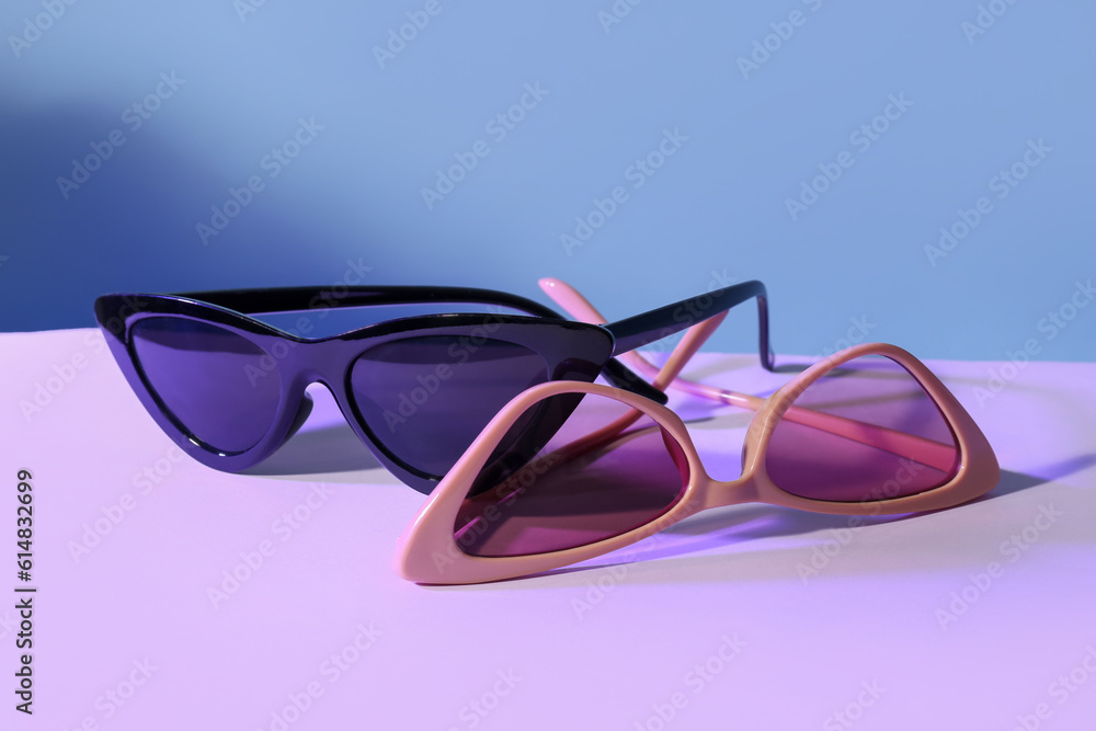 Different stylish sunglasses on colorful background