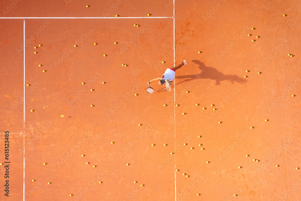 Healthy lifestyle. A young girl plays tennis on the court. The view from the air on the tennis playe