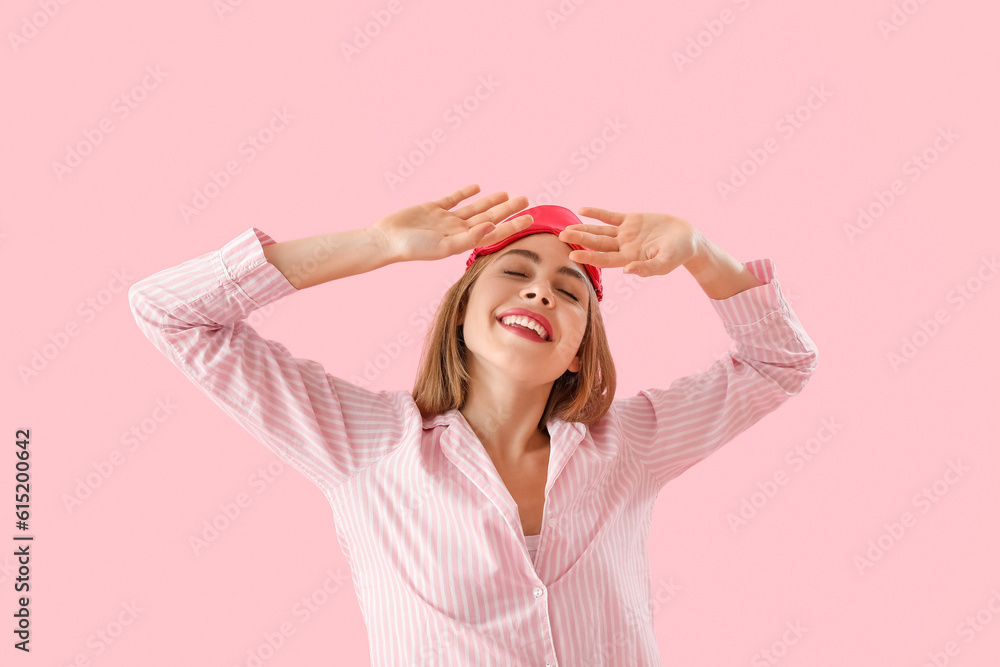 Young woman in pajamas on pink background